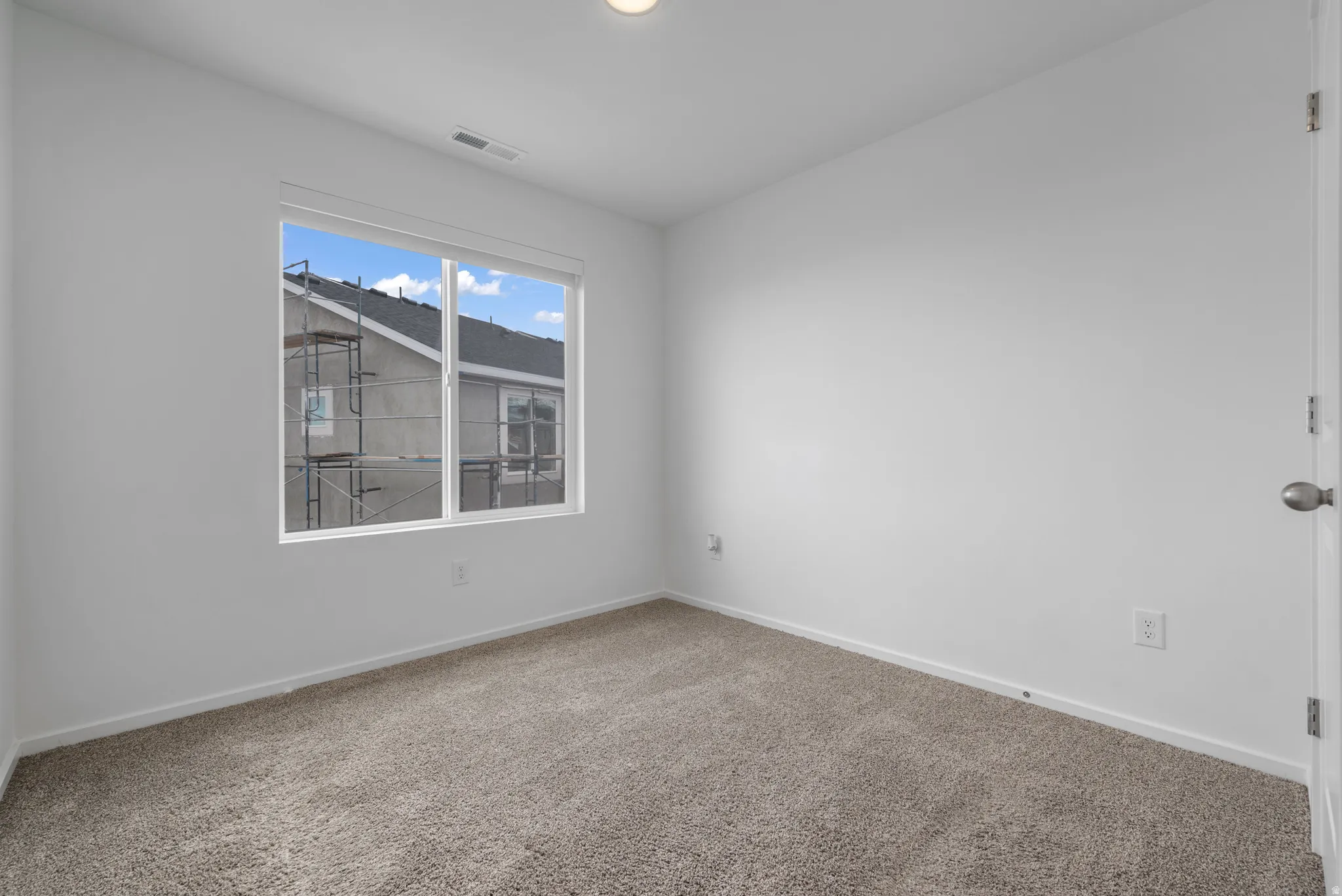 Carpeted empty room featuring baseboards