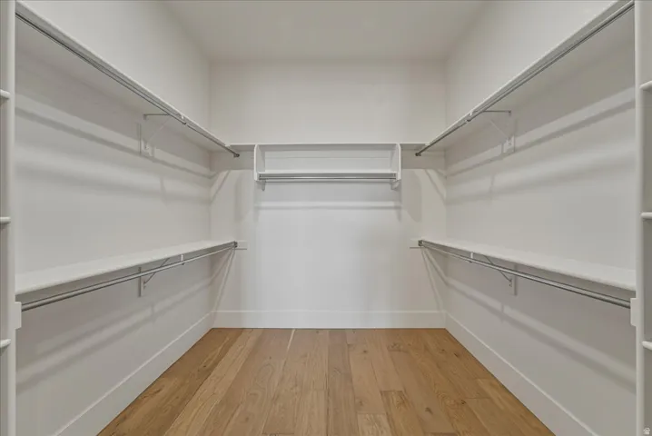 Walk in closet with light wood-style floors