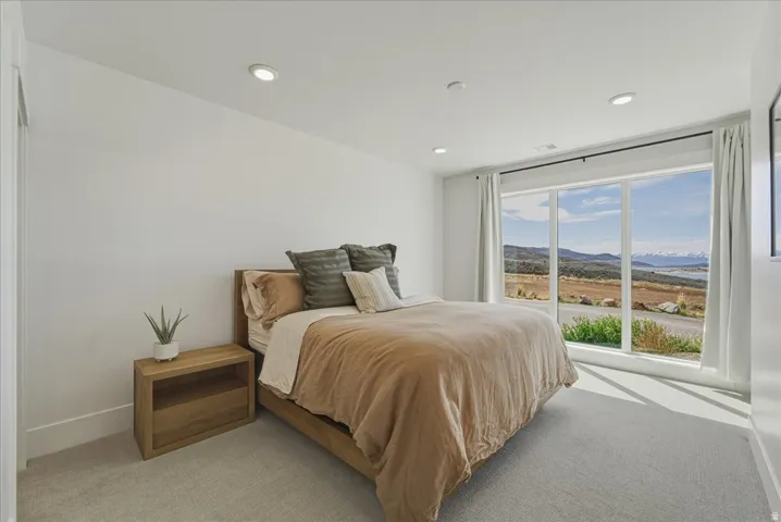 Bedroom with a mountain view, light colored carpet, and recessed lighting