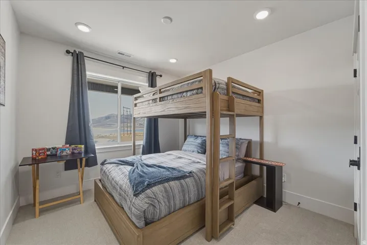 Bedroom with light carpet and recessed lighting