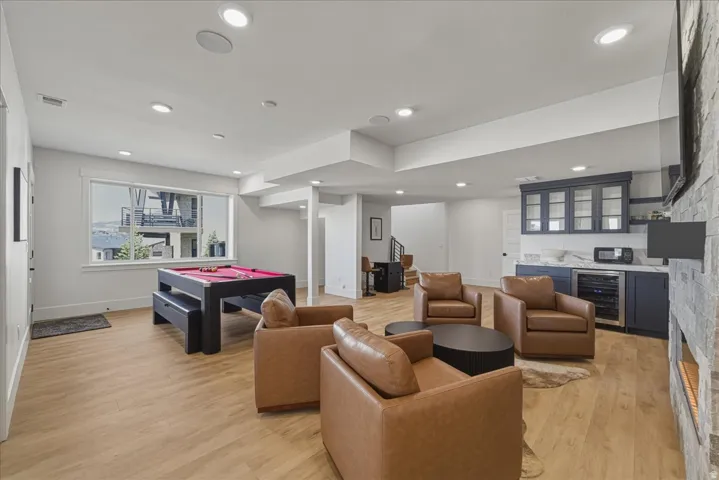Playroom with wine cooler, light wood-style flooring, bar, billiards table, and recessed lighting