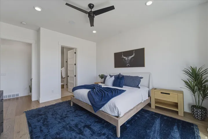 Bedroom featuring wood finished floors, ceiling fan, recessed lighting, and connected bathroom