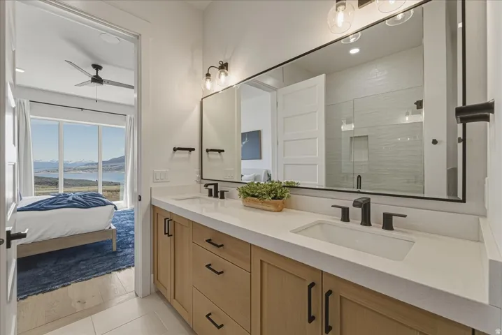 Bathroom featuring double vanity, a water and mountain view, ensuite bathroom, a shower stall, and recessed lighting