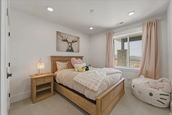Bedroom with light colored carpet and recessed lighting