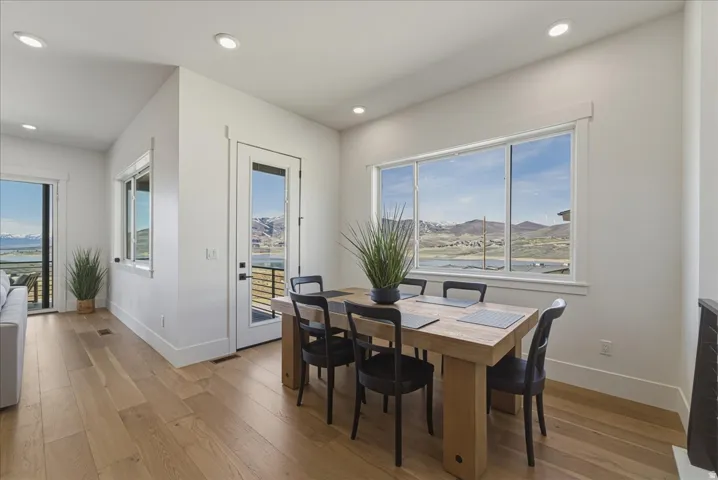 Dining area featuring light wood-style flooring, healthy amount of natural light, recessed lighting, and a mountain view