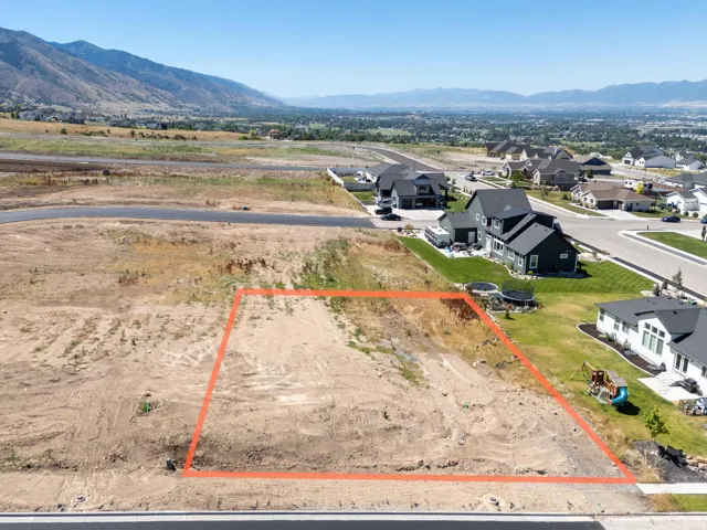 Aerial perspective of suburban area with property boundaries highlighted and a mountain backdrop