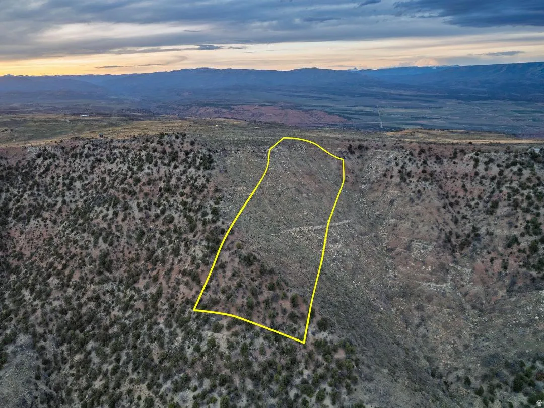 Aerial view at dusk of a mountain view, a desert view, and property parcel outlined