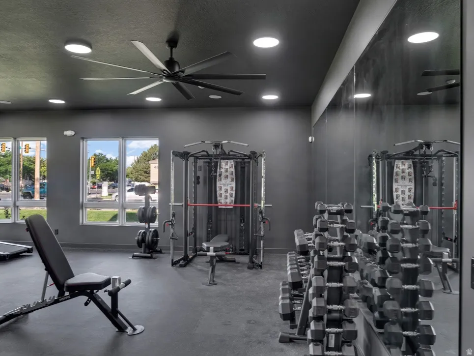 Exercise room featuring a ceiling fan, a textured ceiling, and recessed lighting