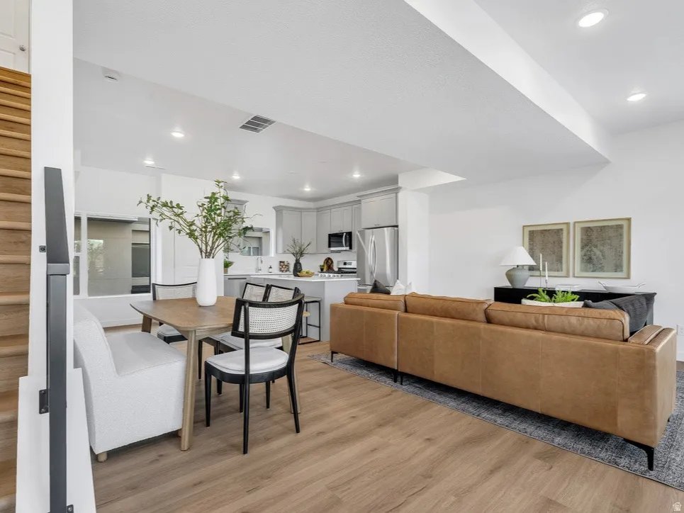 Living room with light wood-type flooring and recessed lighting