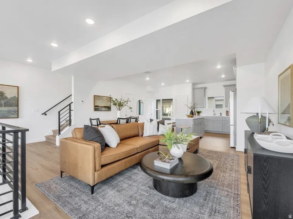 Living room with light wood-style flooring and recessed lighting