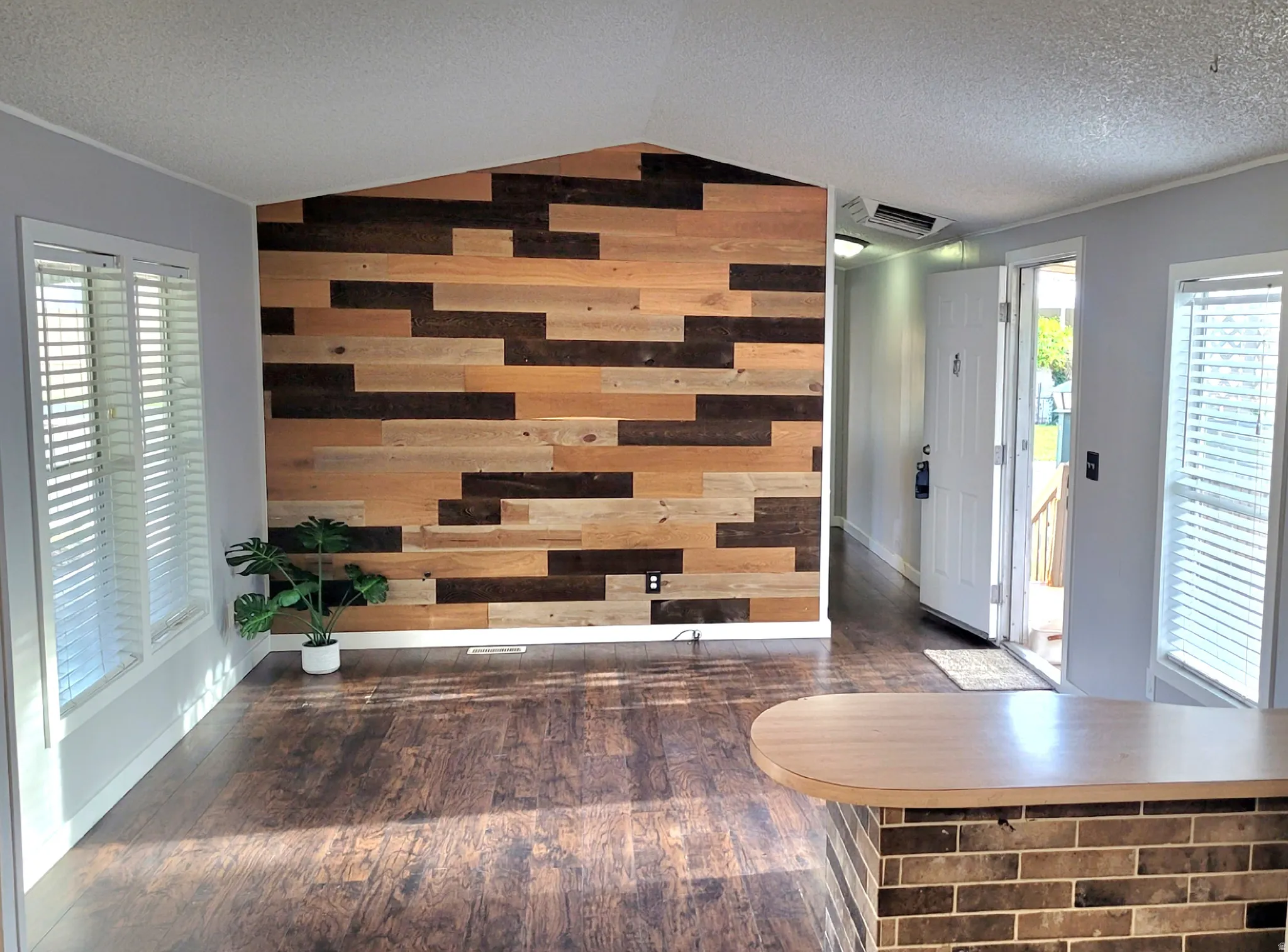 Foyer with plenty of natural light, wood walls, dark wood-style floors, cooling unit, and ornamental molding