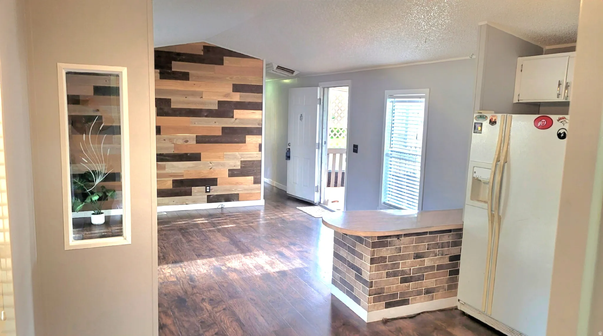 Foyer with dark wood finished floors and wooden walls