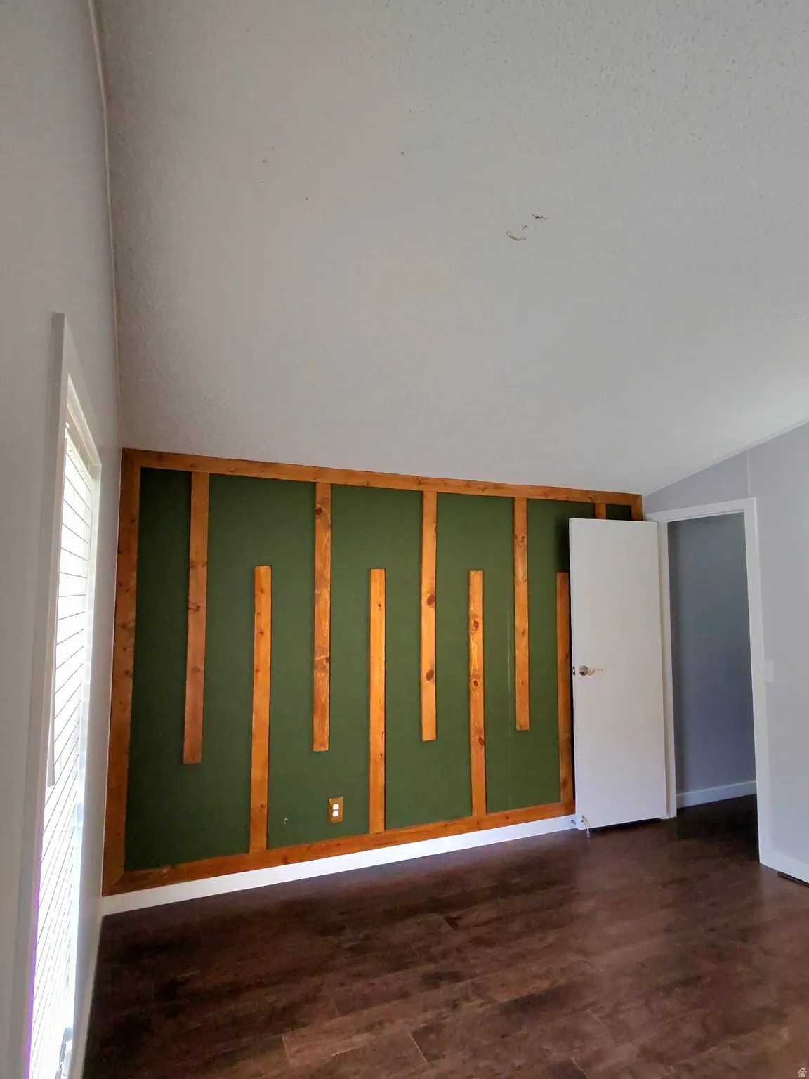 Unfurnished room featuring dark wood finished floors and baseboards