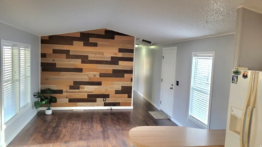 Entrance foyer featuring wood walls, dark wood-style floors, and an accent wall