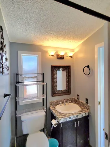 Full primary ensuite with vanity and a textured ceiling