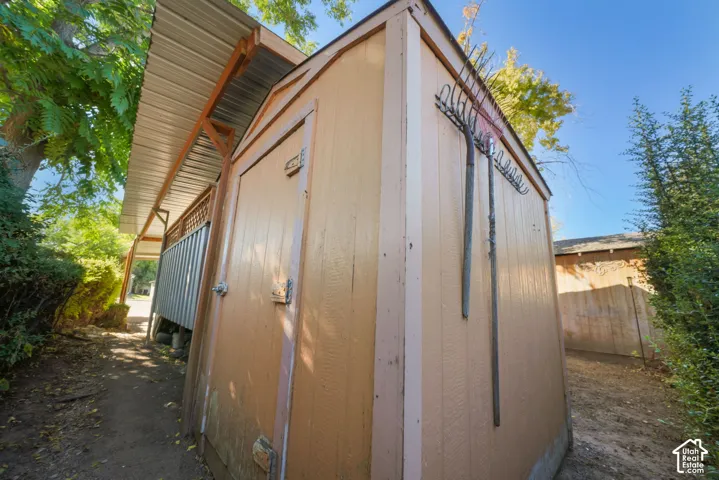 Exterior storage shed featuring a painted wood-panel finish