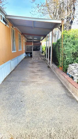 View of parking featuring an attached carport and driveway