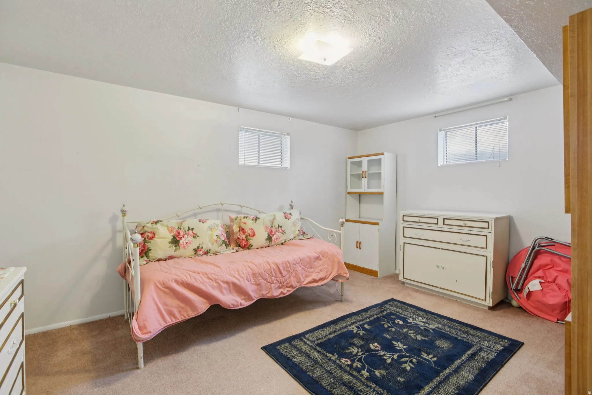 Bedroom featuring a textured ceiling and light carpet