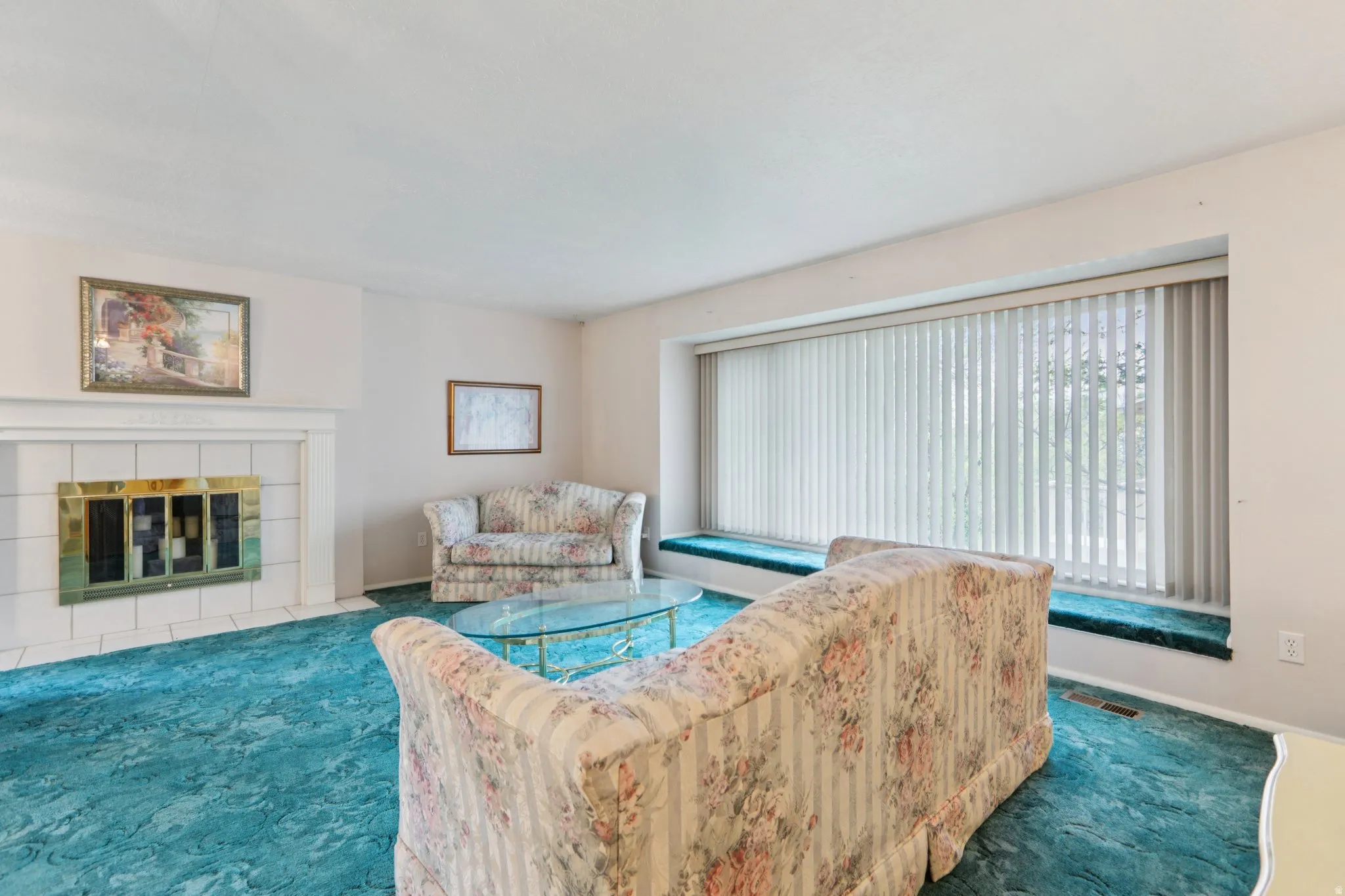 Carpeted living room featuring a tiled fireplace and plenty of natural light