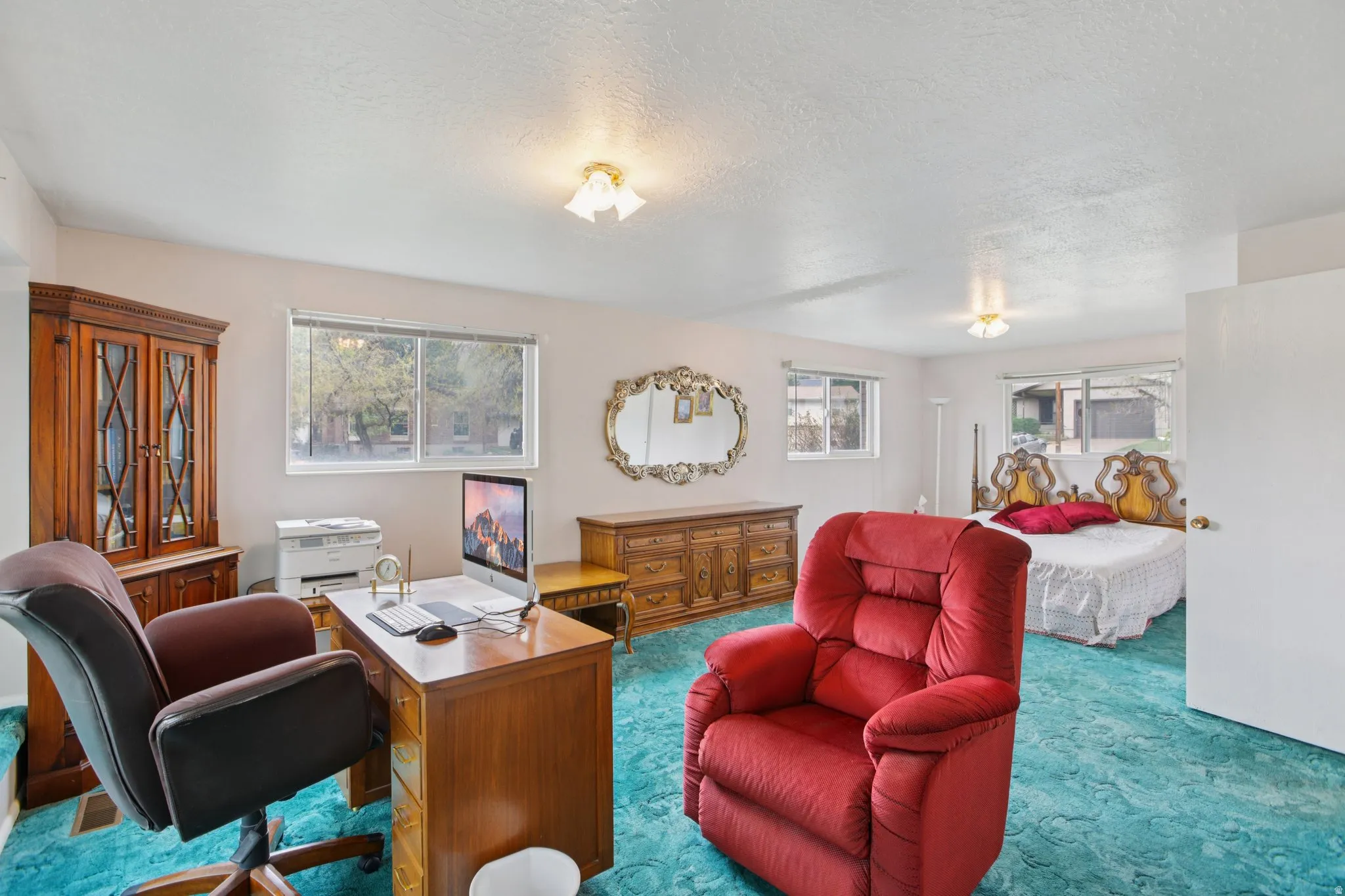 Home office featuring carpet and a textured ceiling