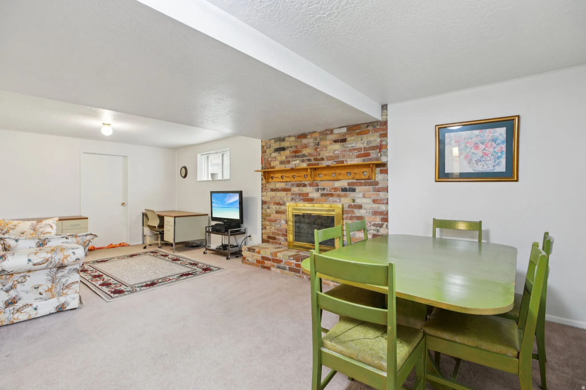 Carpeted dining area with a brick fireplace and a textured ceiling