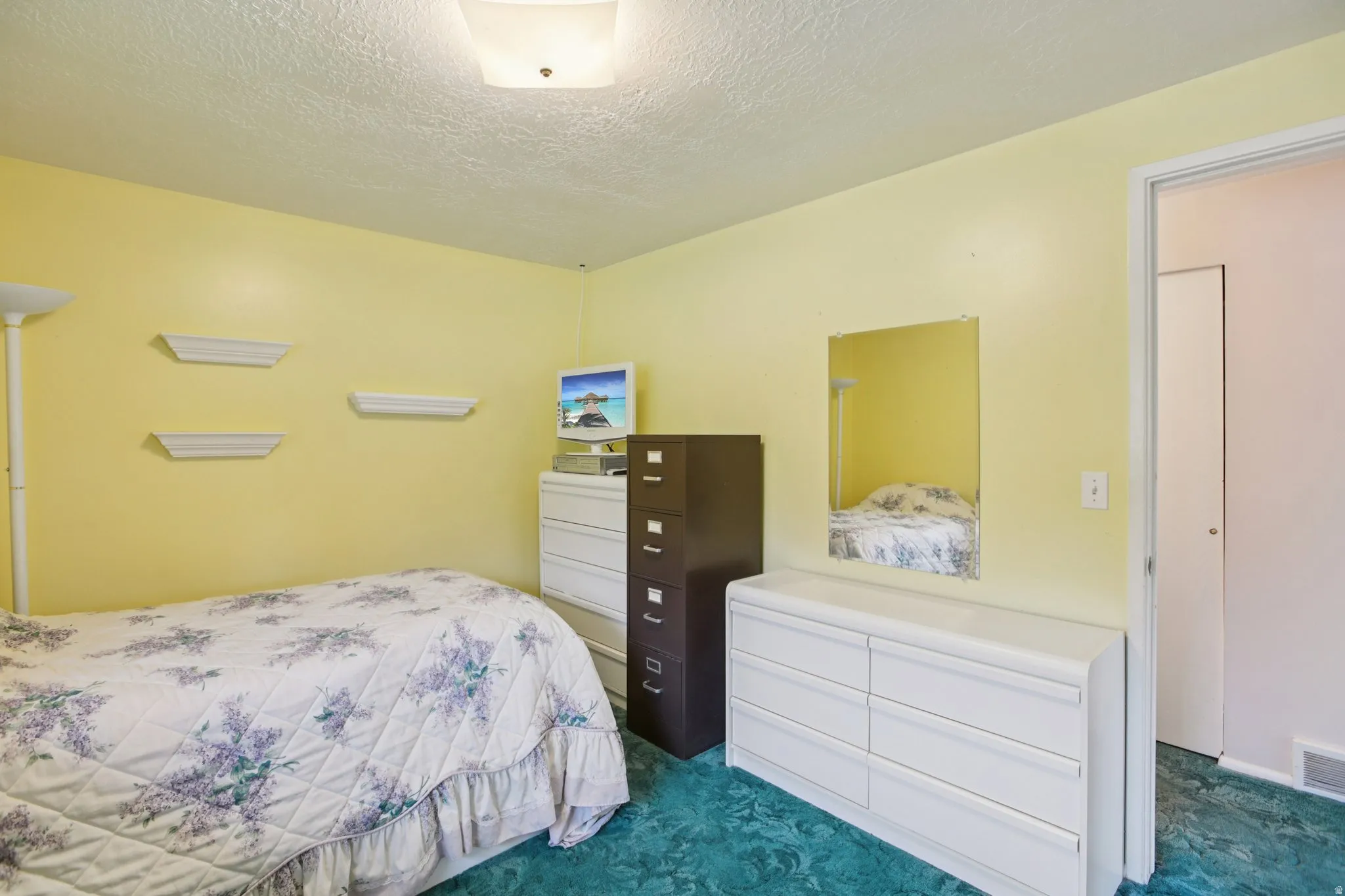 Bedroom featuring a textured ceiling and dark colored carpet