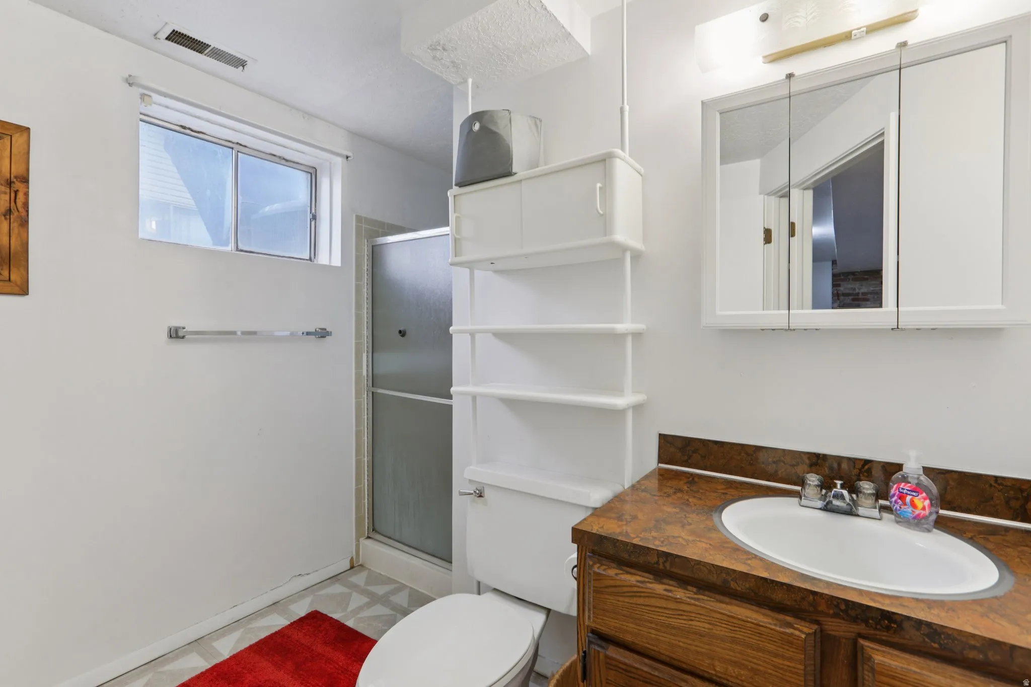 Full bath with a shower stall, vanity, and light flooring