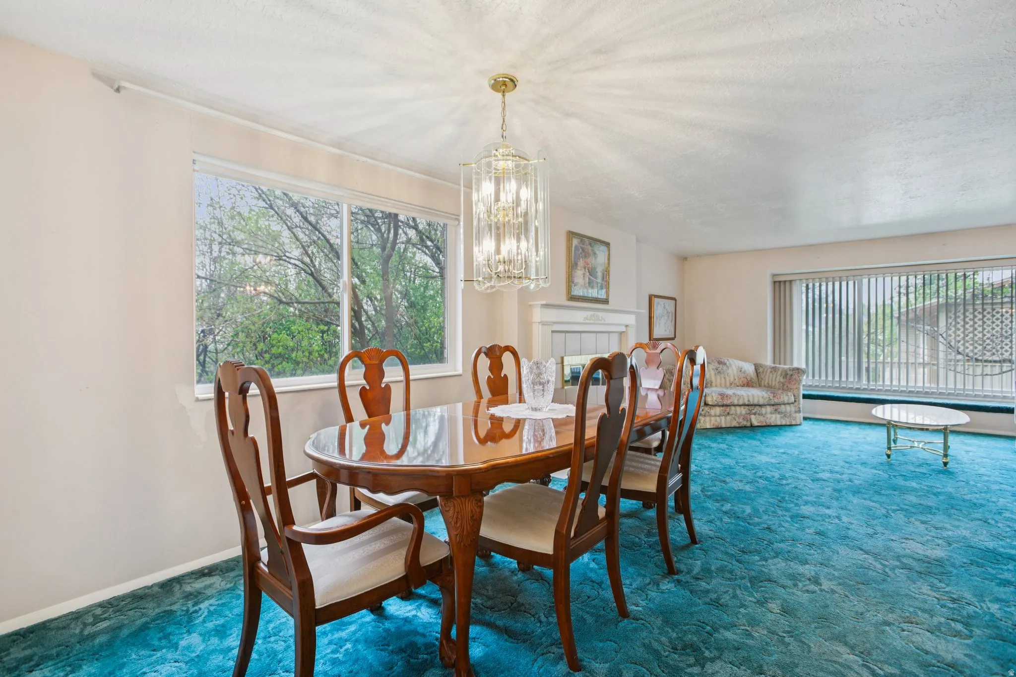Carpeted dining space featuring a chandelier and baseboards
