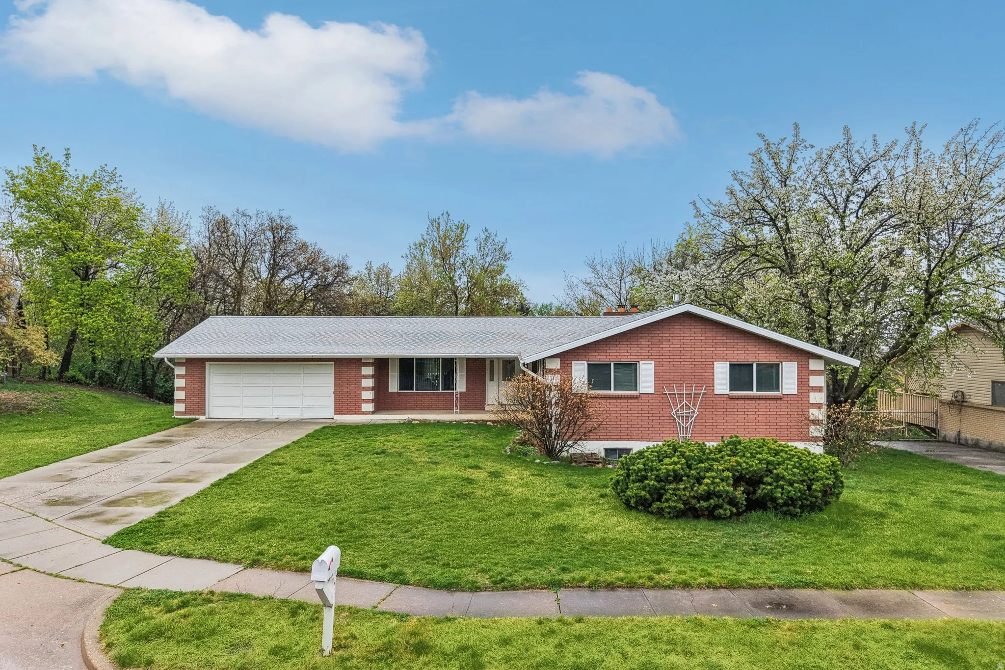 Ranch-style house with brick siding, driveway, covered porch, and a garage