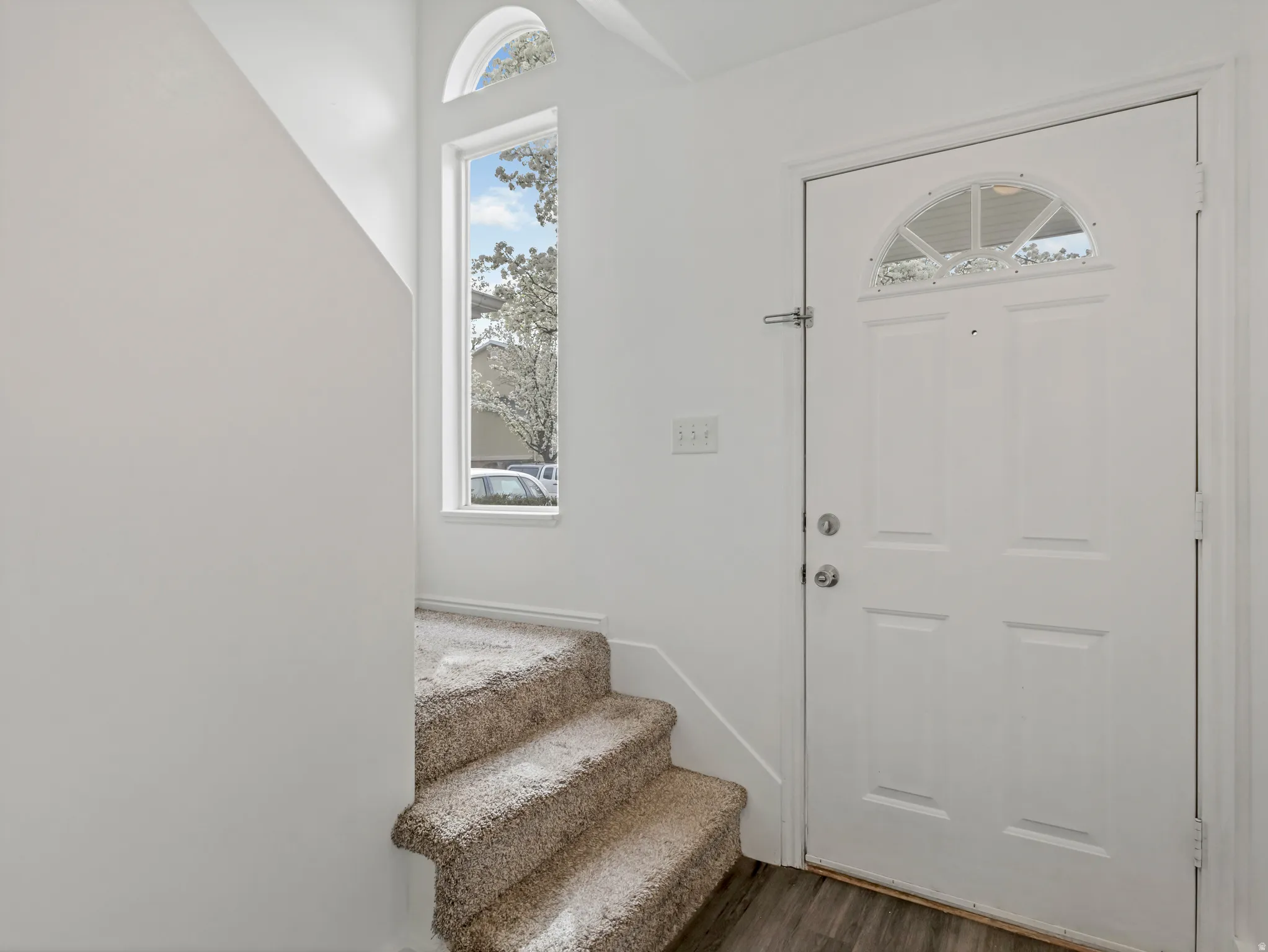 Entrance foyer featuring dark wood-style flooring and stairs