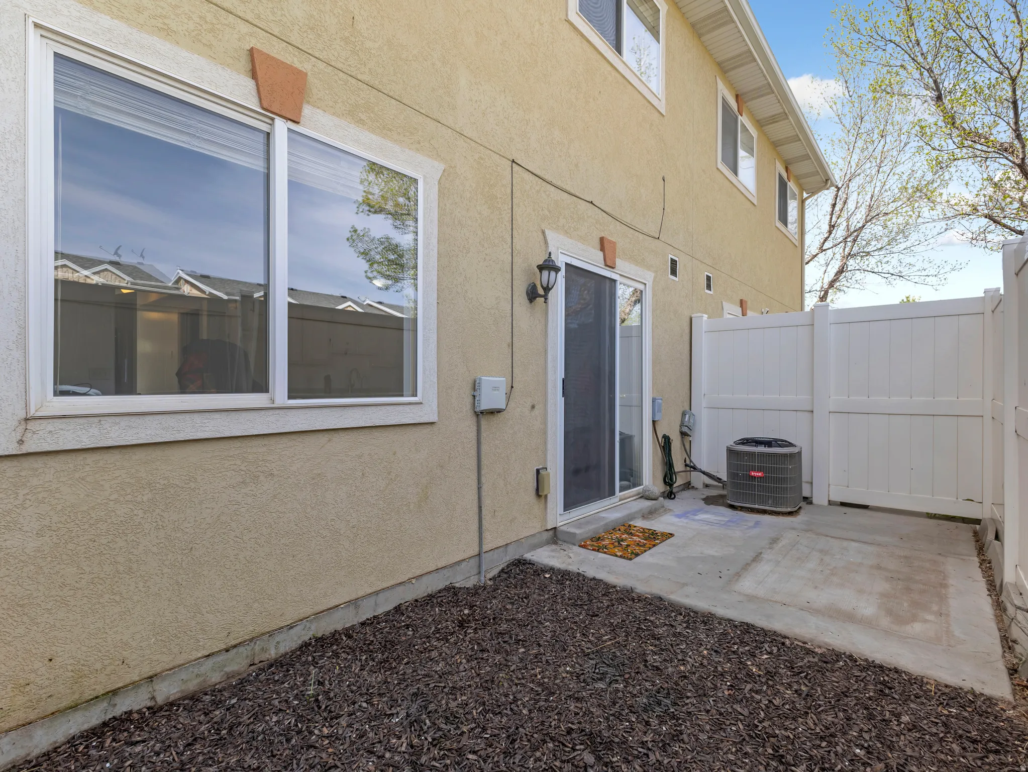 Property entrance with stucco siding and a patio