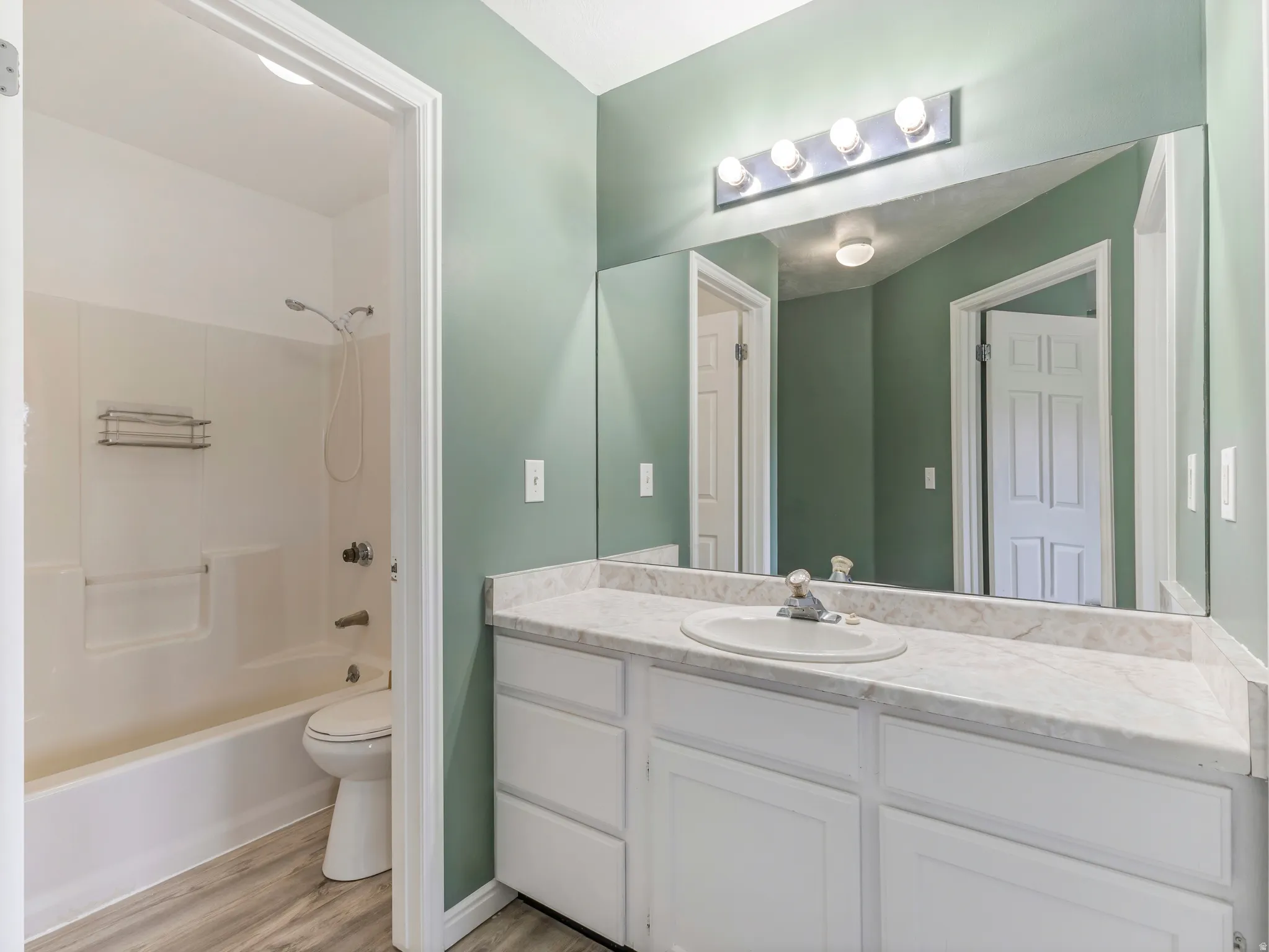 Full bath with vanity, tub / shower combination, and light wood-style floors