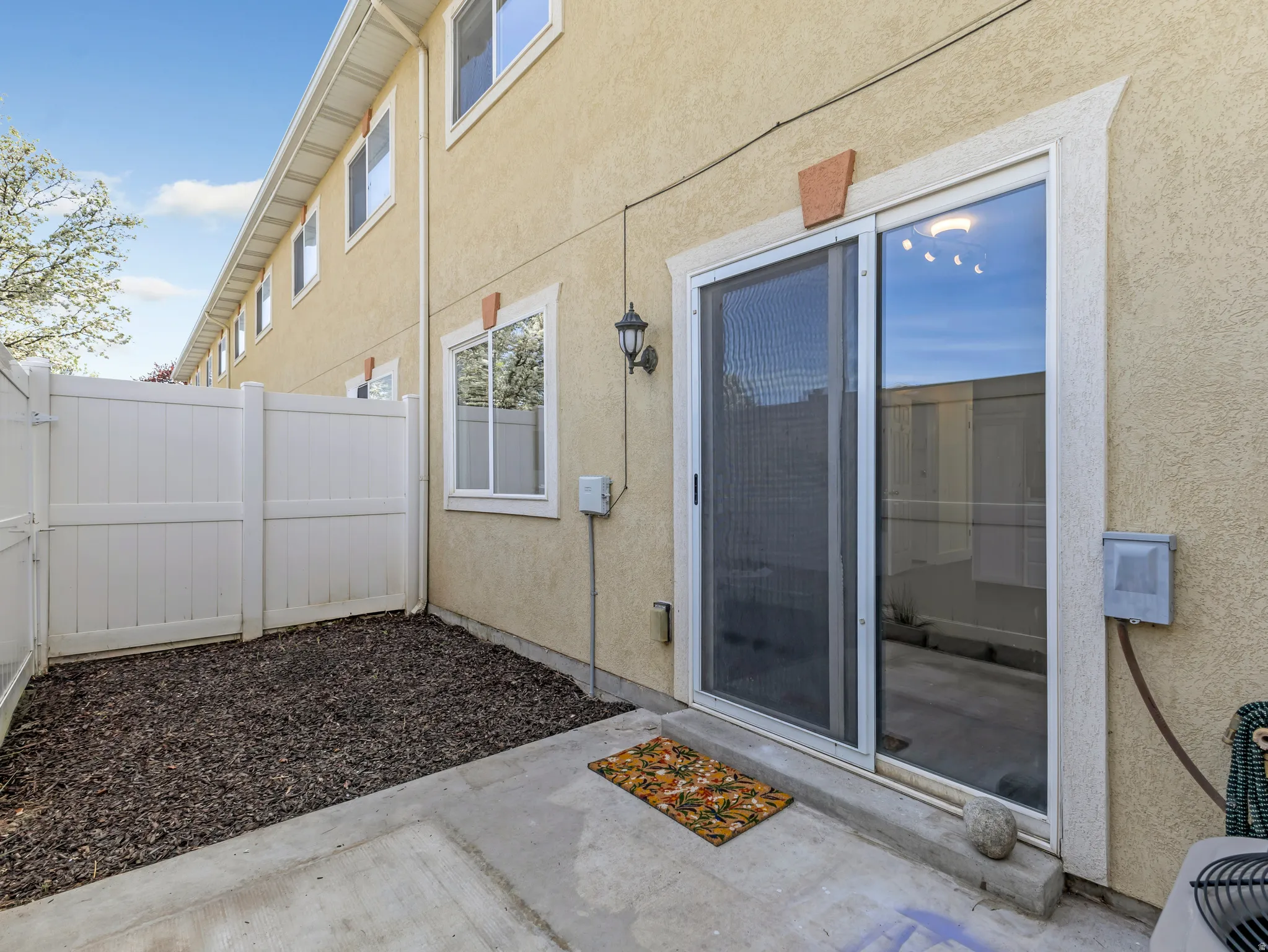 Property entrance with stucco siding and a patio area