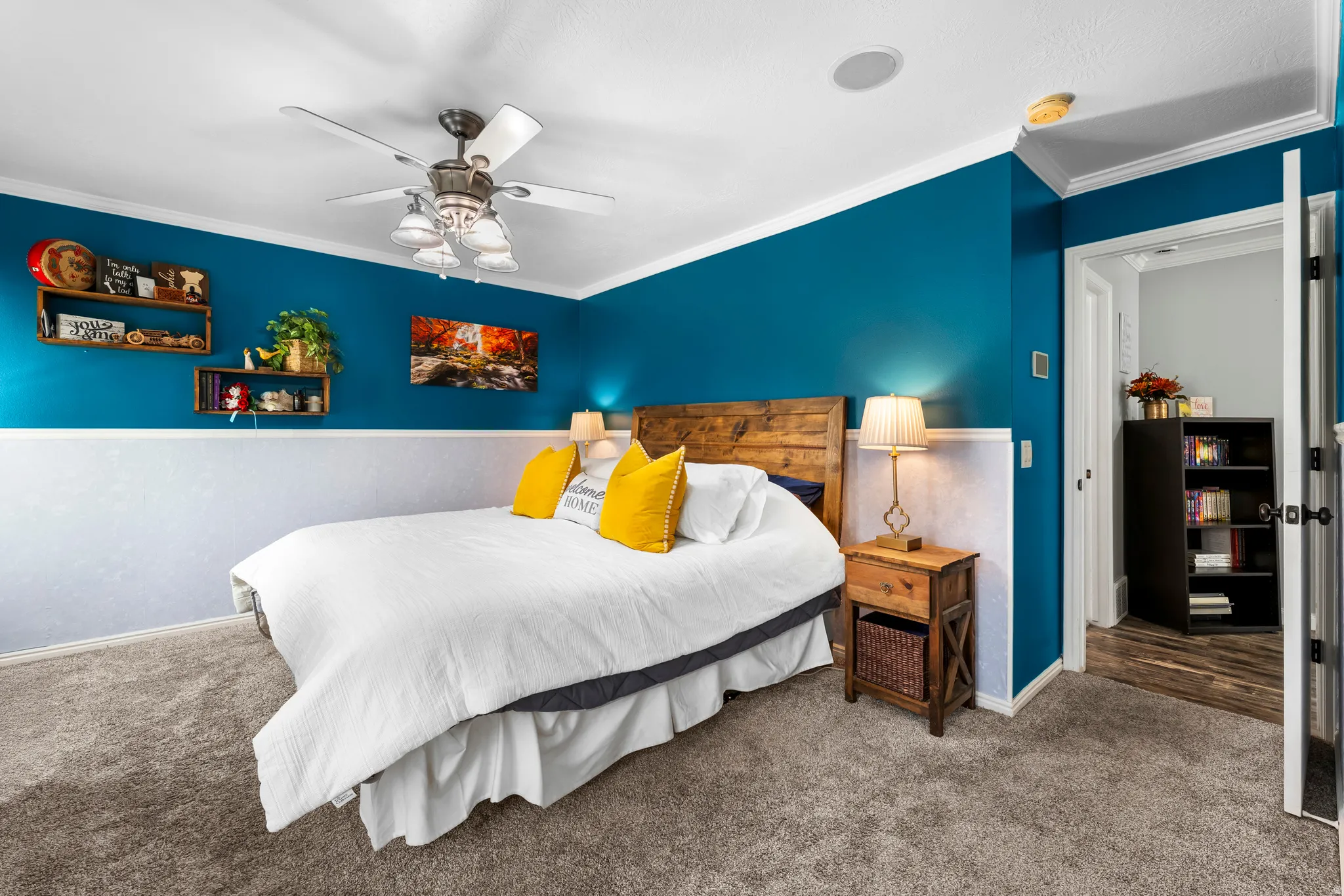 Primary bedroom with ceiling fan and en suite bath and walk-in closet