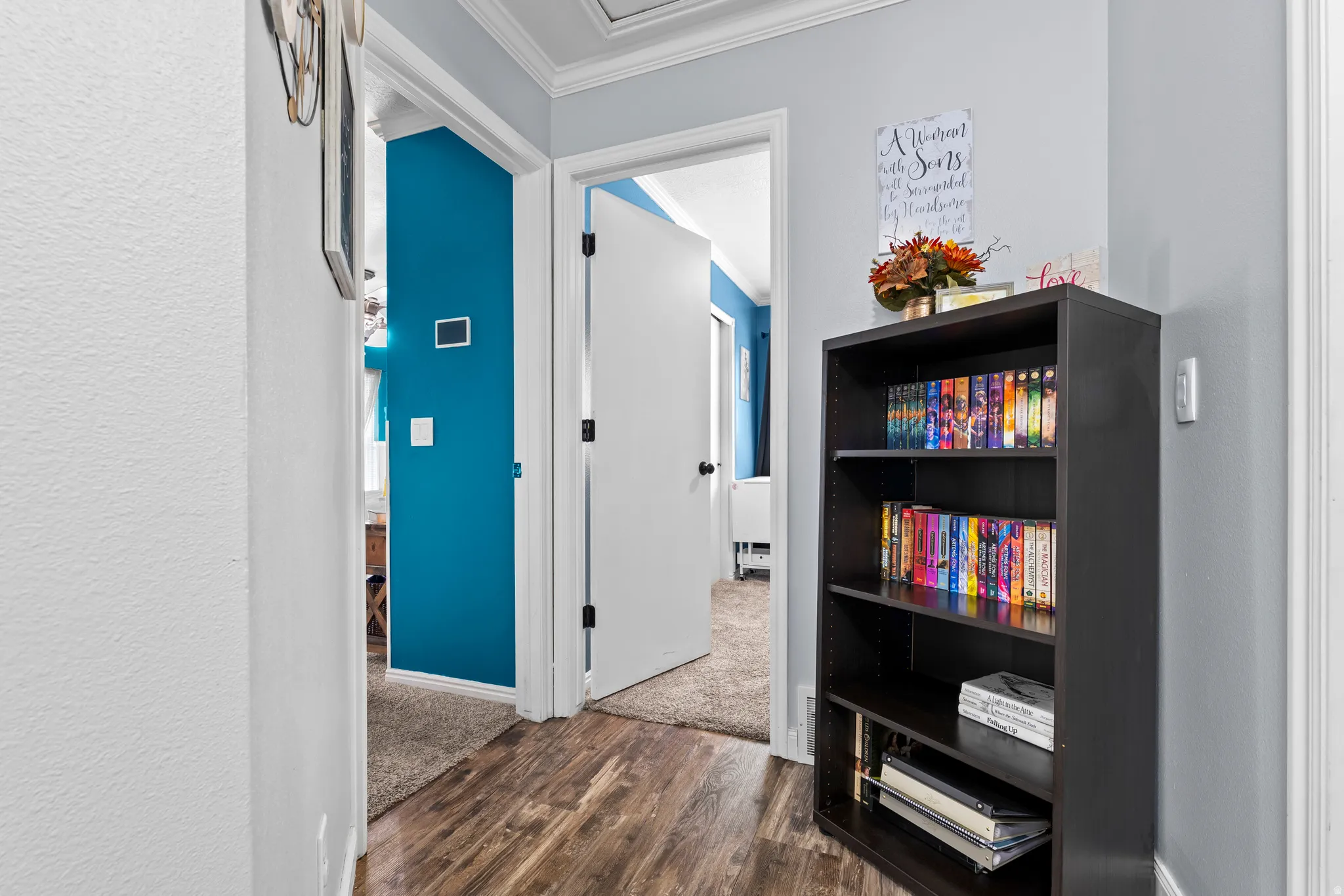 Corridor featuring dark wood-type flooring and ornamental molding