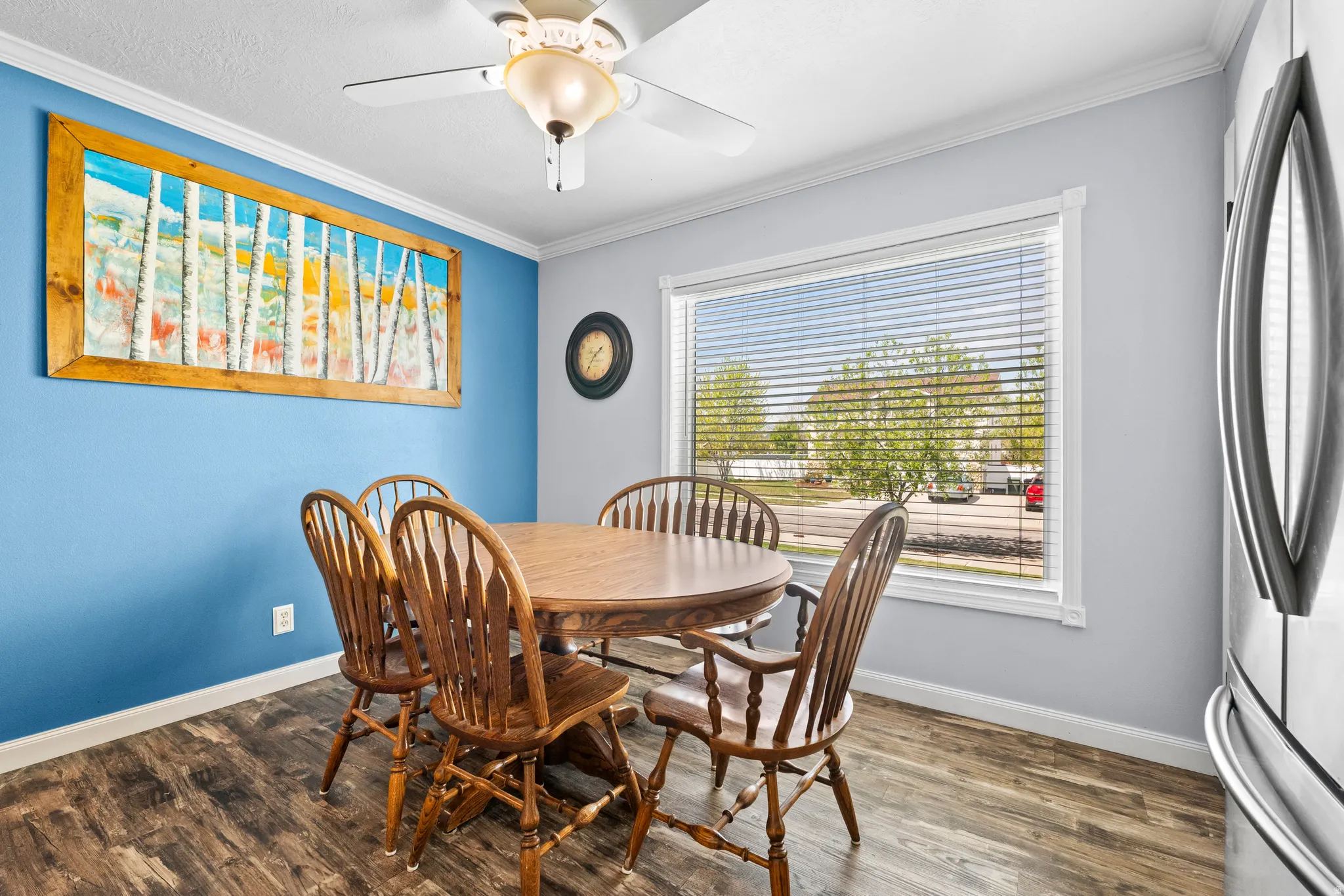 Dining area in kitchen with a ceiling fan, LVP flooring and a picture window.