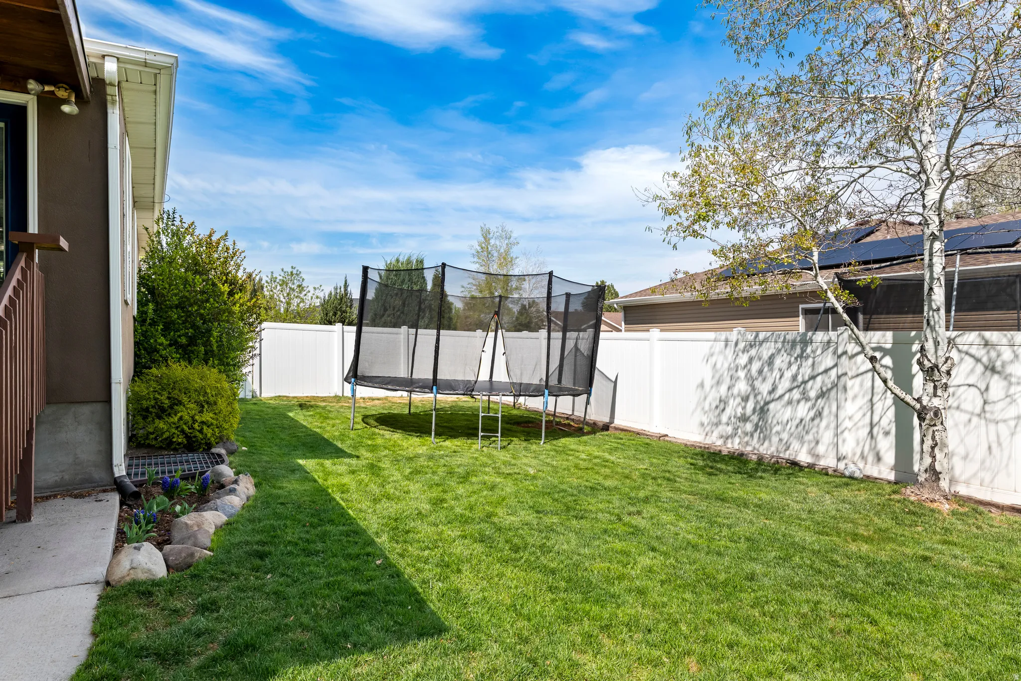 Fenced backyard featuring a trampoline (Included!)