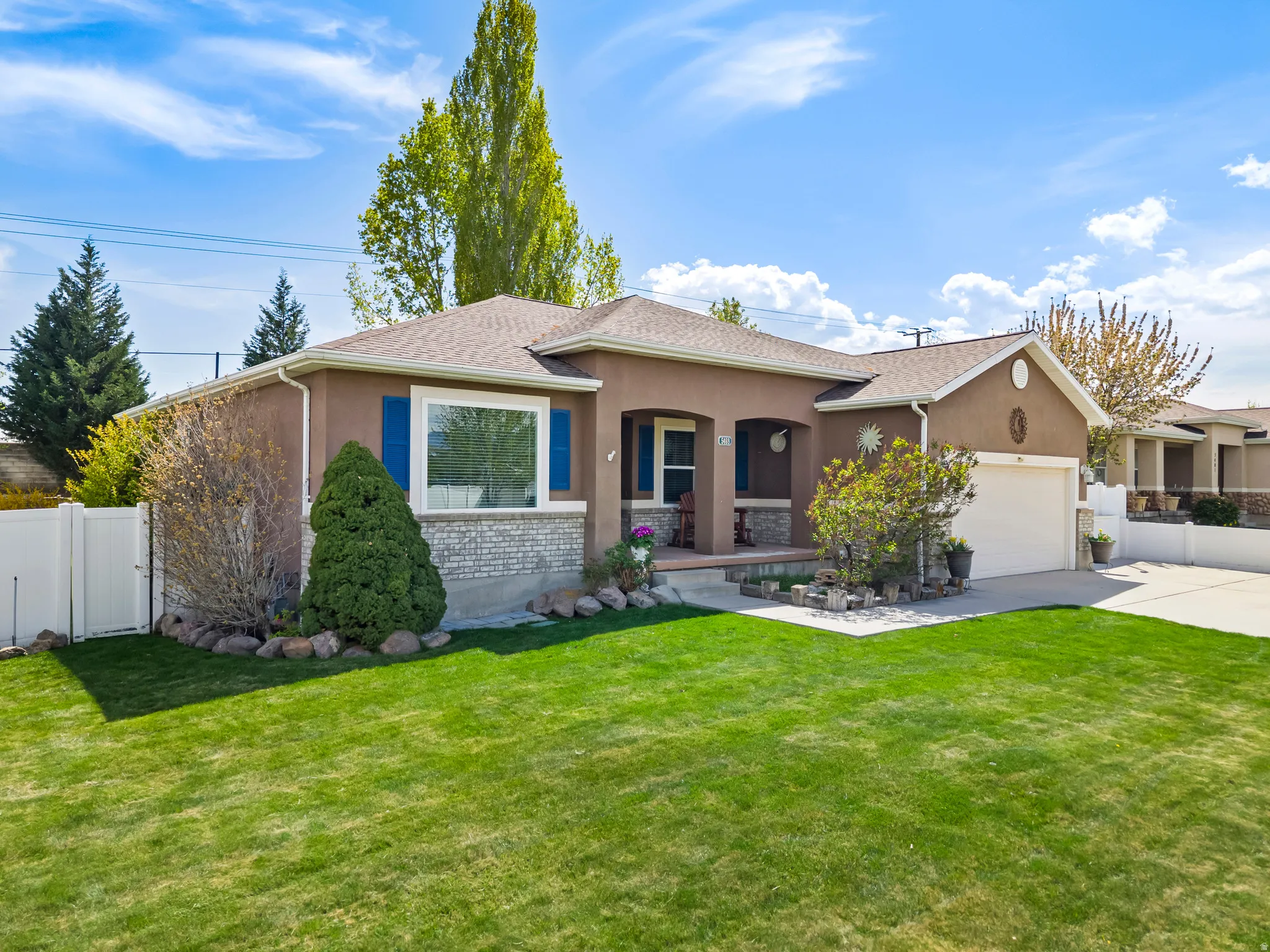 View of front of home with a garage, a porch, stucco siding, concrete driveway, and a gate