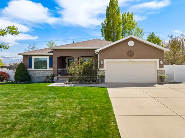 View of front facade with stucco siding, a garage, concrete driveway, and covered porch