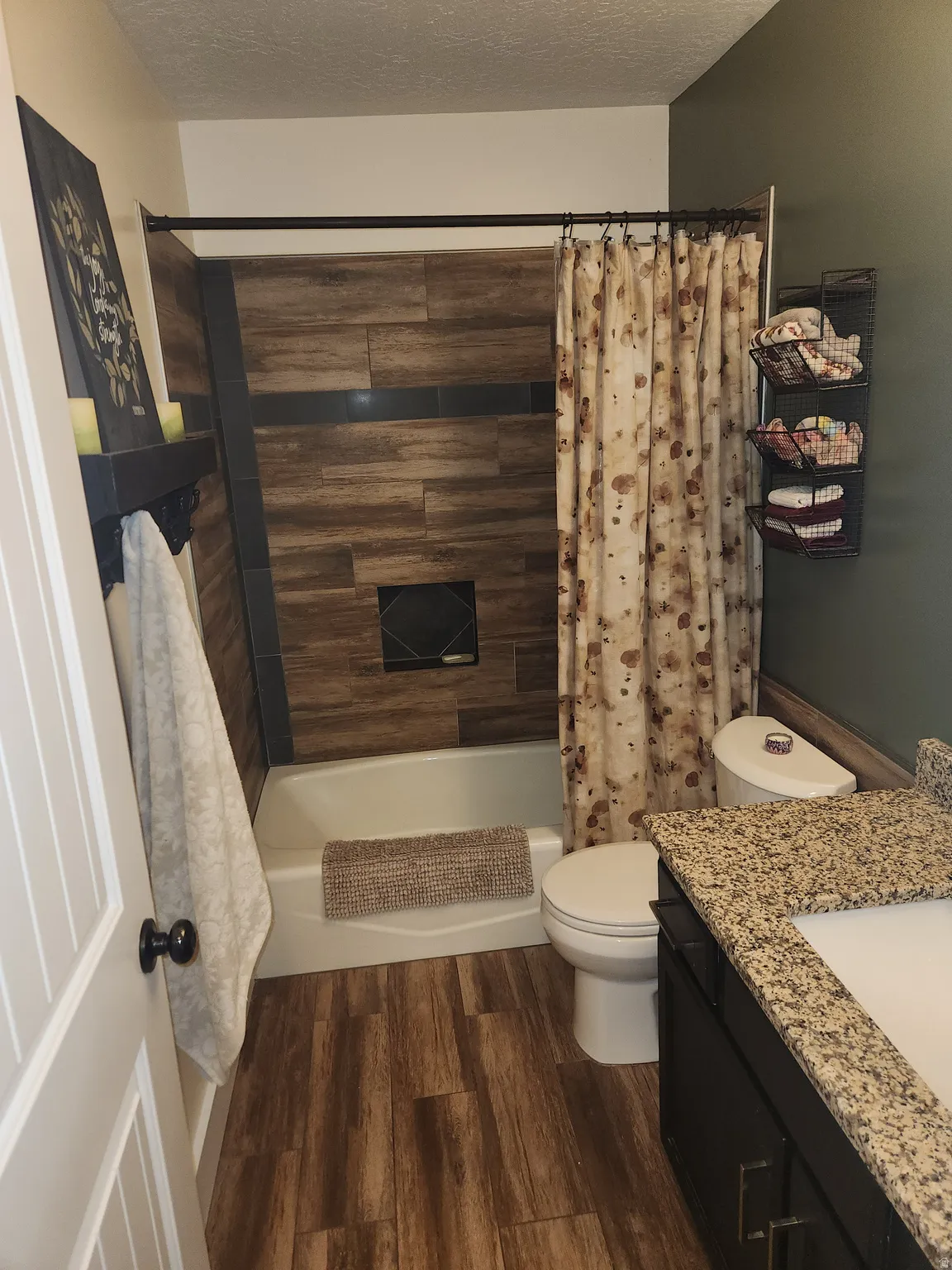 Full bath featuring vanity, dark wood-style floors, a textured ceiling, and shower / bath combination with curtain