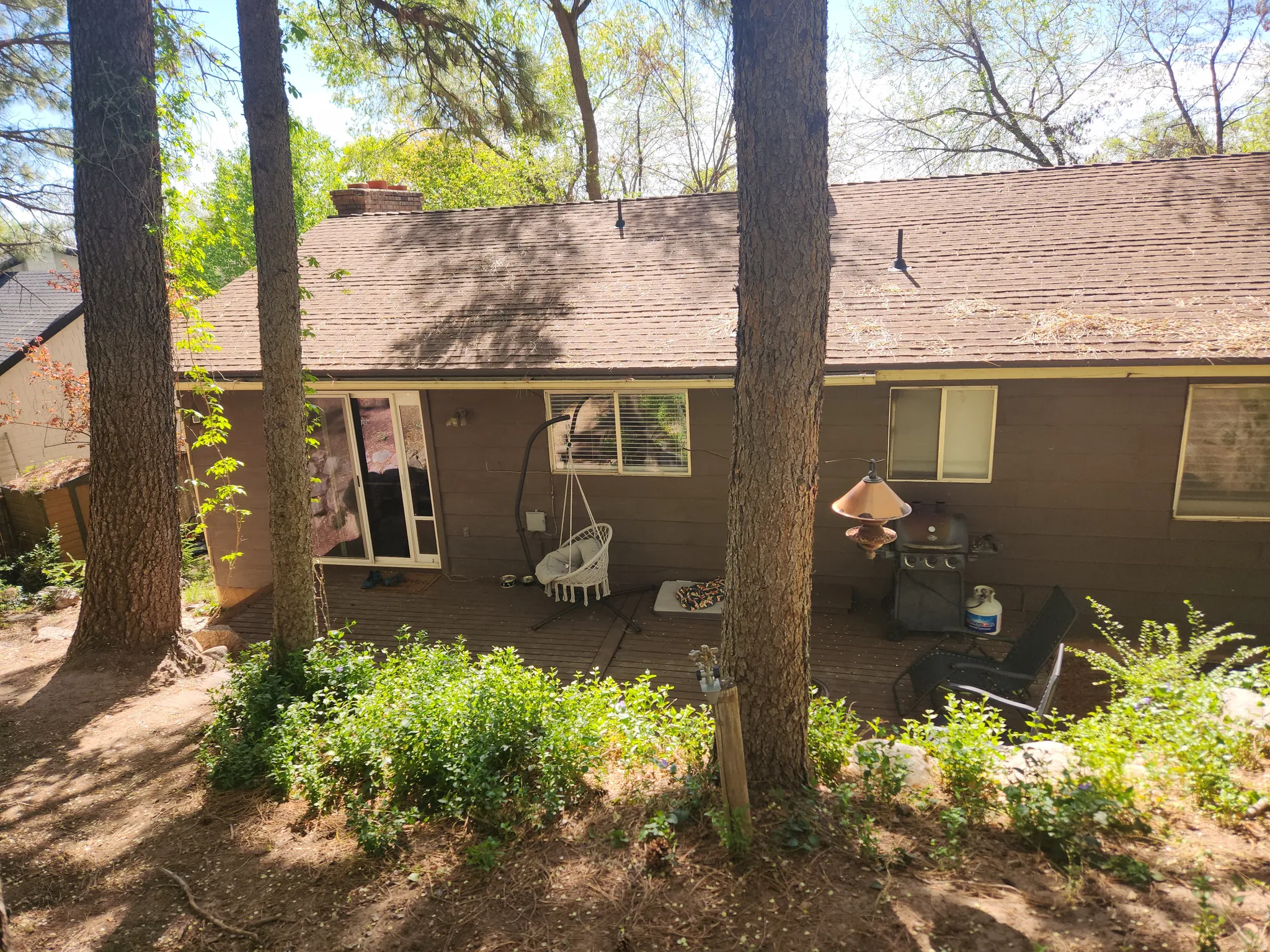 Rear view of property with a wooden deck, a chimney, and roof with shingles