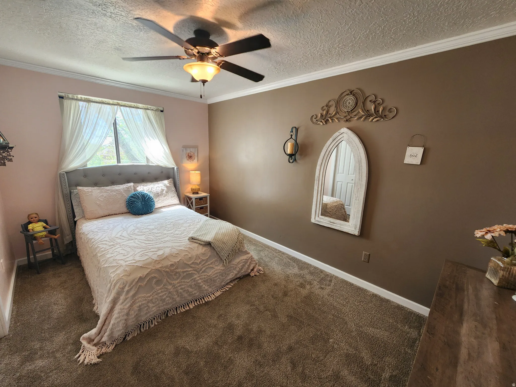Bedroom with crown molding, a textured ceiling, carpet, and a ceiling fan