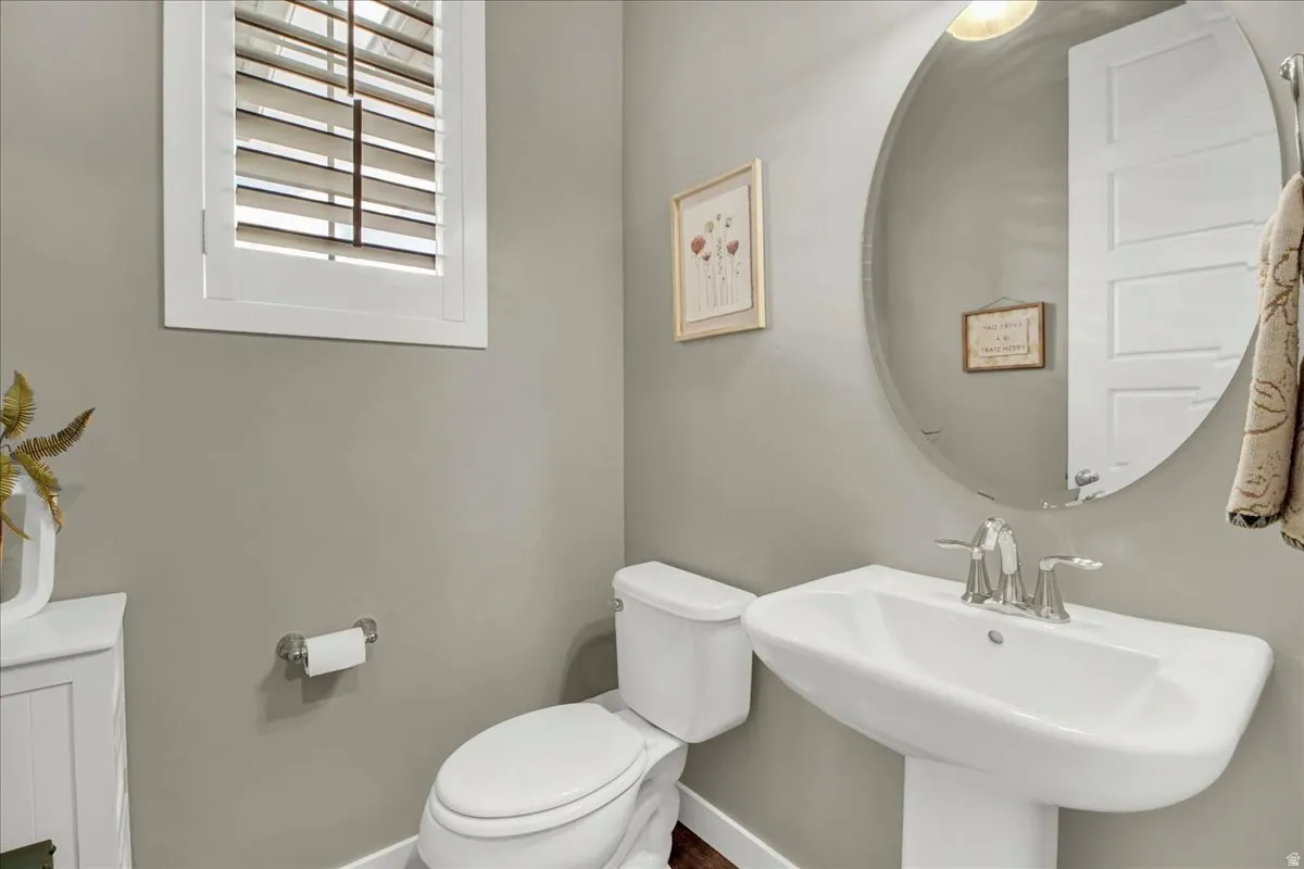 Half bathroom with toilet and baseboards