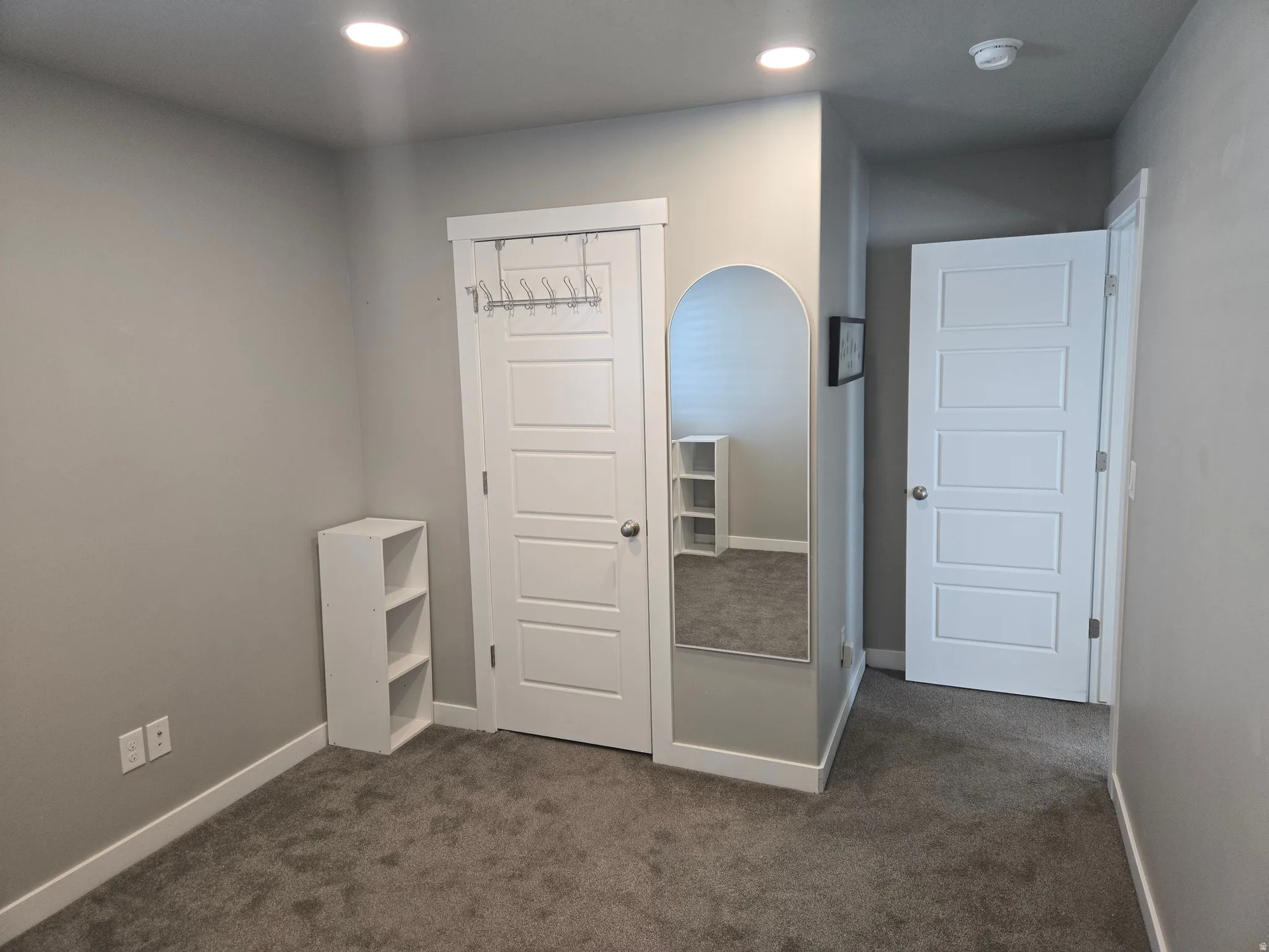 Neutral gray wall tones, recessed ceiling lighting, and gray carpeting