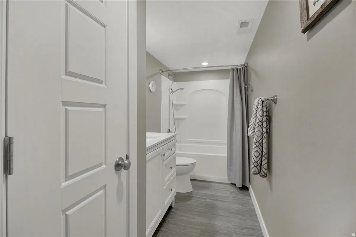 Full bathroom with vanity, shower / tub combo, and recessed lighting