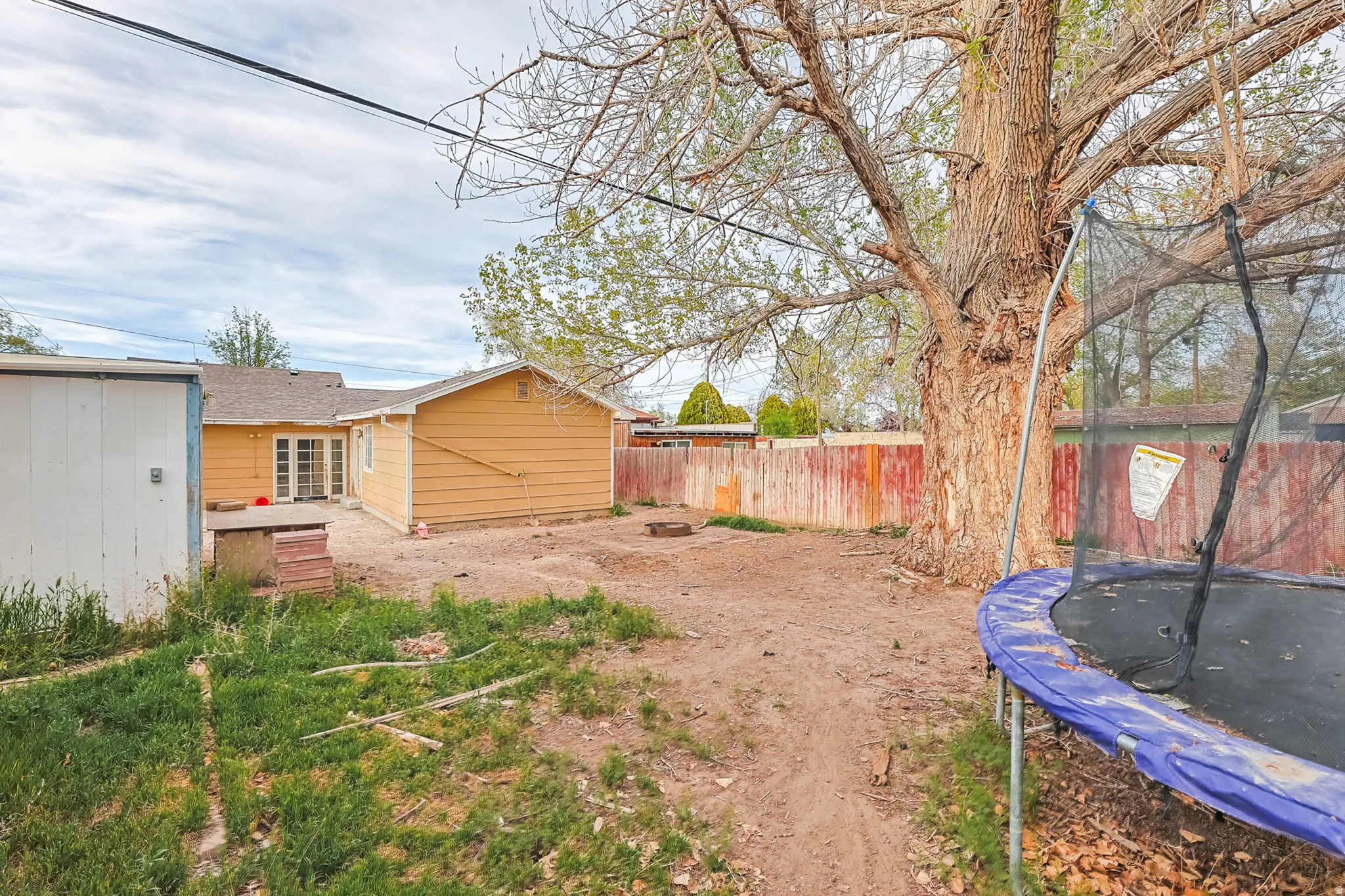 Fenced backyard with a trampoline
