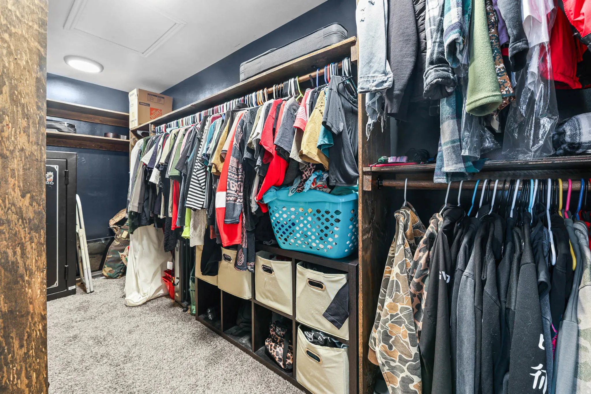 Walk in closet with light colored carpet and attic access