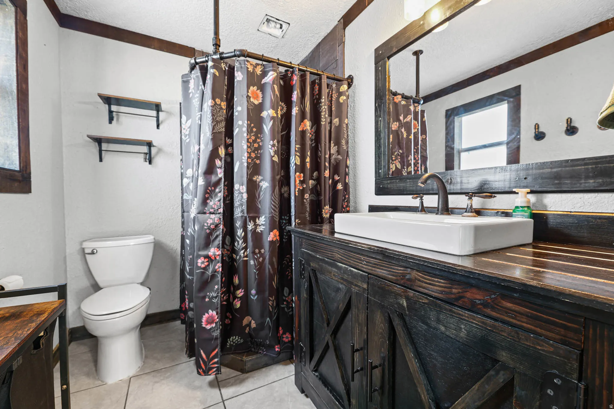 Full bath featuring vanity, a textured wall, a textured ceiling, a shower with curtain, and light tile patterned floors