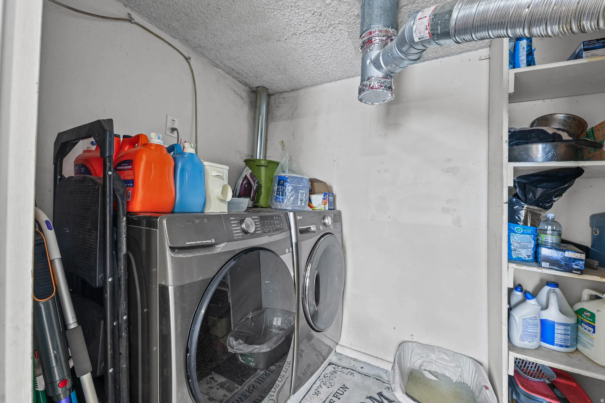 Laundry room with washing machine and dryer and concrete flooring