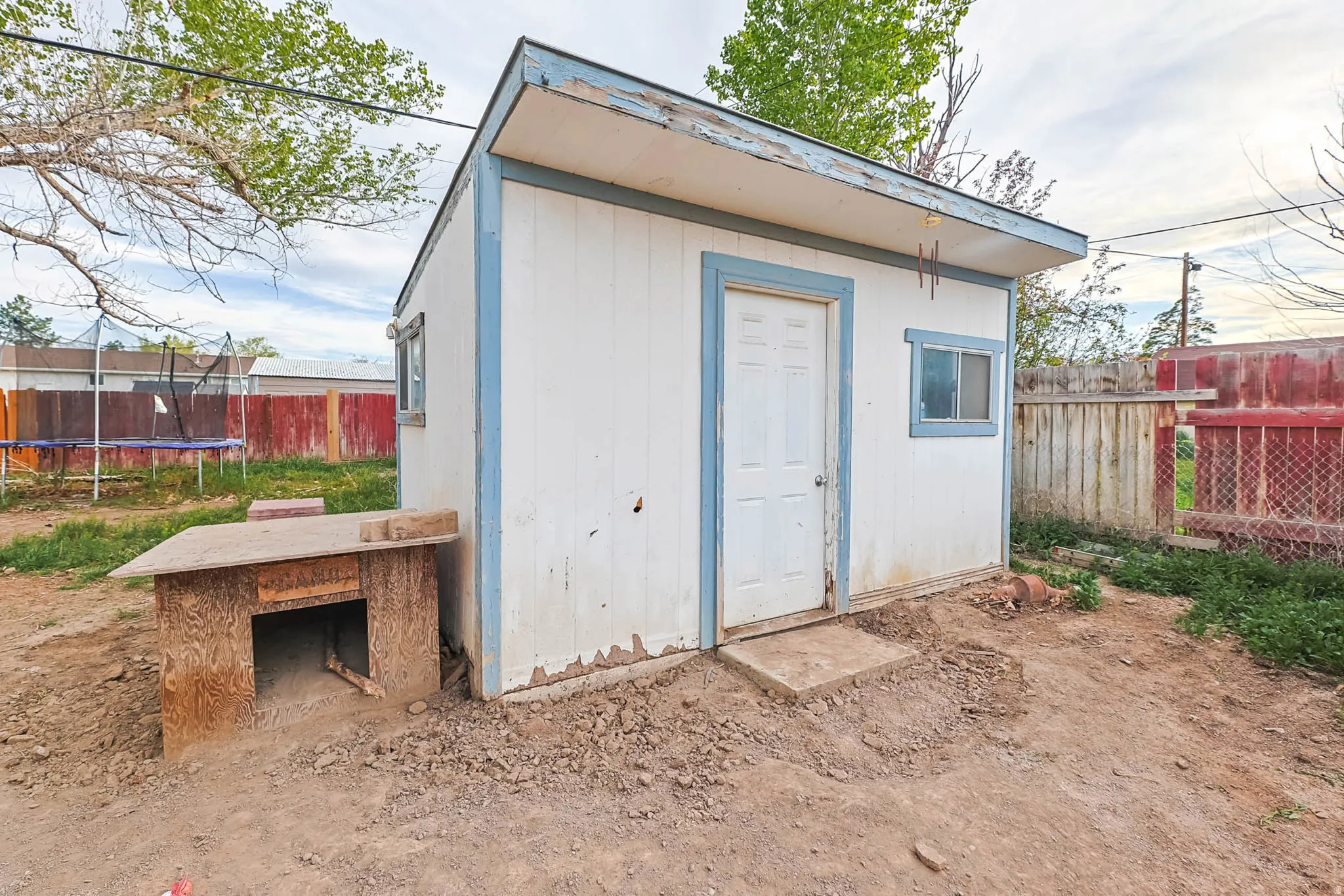 View of shed featuring a trampoline and a fenced backyard
